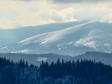 Önde karla kaplı dağ zirvesi