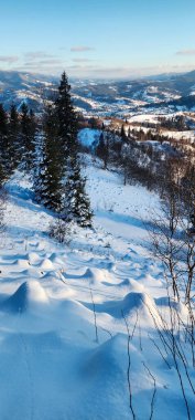 Kışın gün batımında karlı dağ yamacı