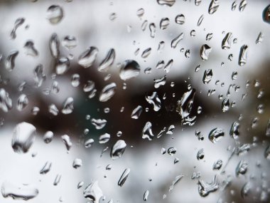Üzerinde yağmur damlaları olan bir pencere.
