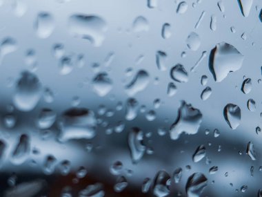 Üzerinde yağmur damlaları olan bir pencere.