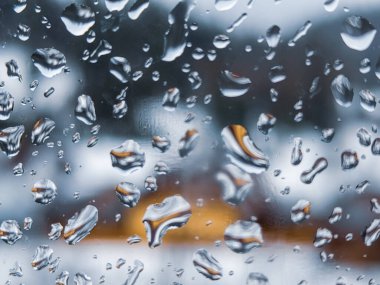 Üzerinde yağmur damlaları olan bir pencere.