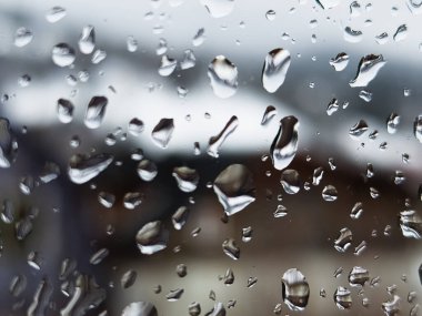 Üzerinde yağmur damlaları olan bir pencere.