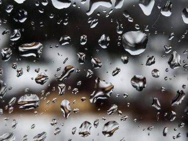 Üzerinde yağmur damlaları olan bir pencere.