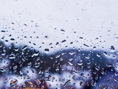 Bir sürü su damlası olan yağmurlu bir pencere.