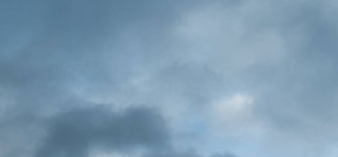 Bulutlu bir arka planı olan gökyüzünde uçan bir uçak.