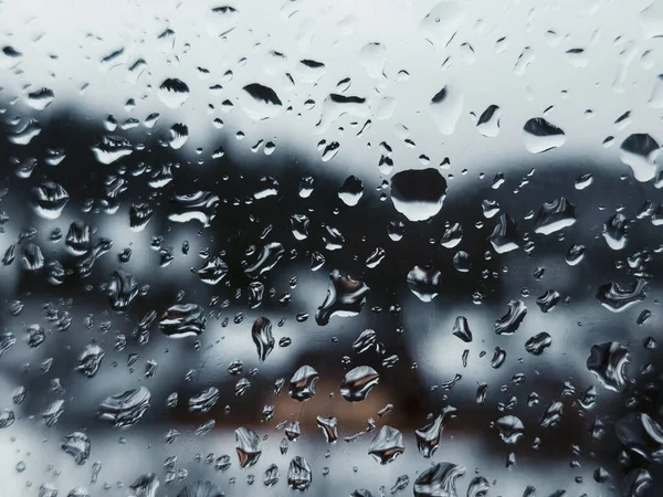 Üzerinde yağmur damlaları olan bir pencere.