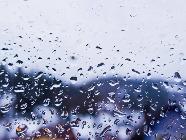 Bir sürü su damlası olan yağmurlu bir pencere.