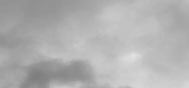 Bulutlu bir arka planı olan gökyüzünde uçan bir uçak.