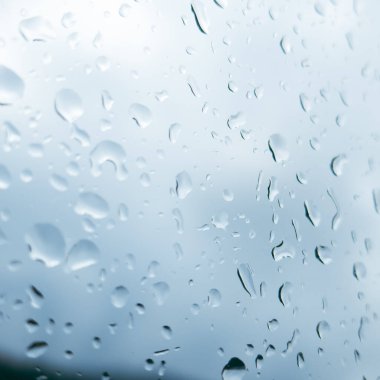 bardağa damlatıyor. Bir arabaya yağmur damlaları düşer.