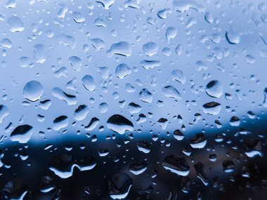 Mavi gökyüzü ile pencereye yağmur yağar