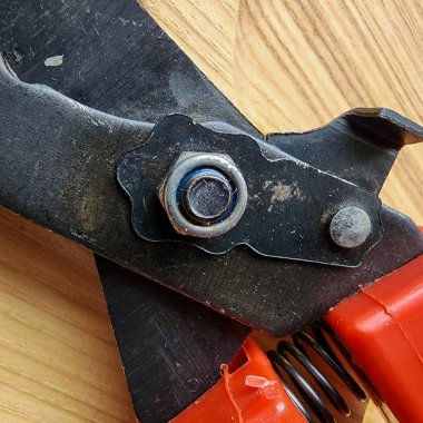 Canlı kırmızı saplı siyah bir bahçe budama makinesi kullanıma hazır, işlevselliği bir renk patlaması ile harmanlıyor. Bu kullanışlı araç kolay ve stil ile bahçıvanlık görevleri ele almak için hazırlanmış.