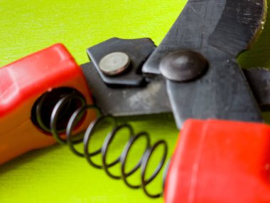 Canlı kırmızı saplı siyah bir bahçe budama makinesi kullanıma hazır, işlevselliği bir renk patlaması ile harmanlıyor. Bu kullanışlı araç kolay ve stil ile bahçıvanlık görevleri ele almak için hazırlanmış.