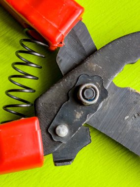 Canlı kırmızı saplı siyah bir bahçe budama makinesi kullanıma hazır, işlevselliği bir renk patlaması ile harmanlıyor. Bu kullanışlı araç kolay ve stil ile bahçıvanlık görevleri ele almak için hazırlanmış.