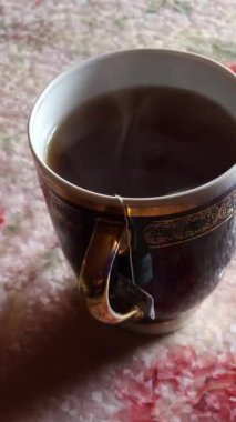 Bir fincan çay, bir çaydanlık ve bir kaşık