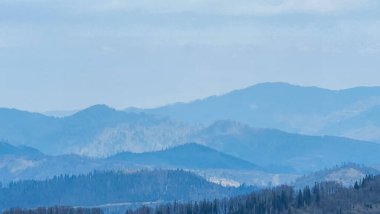 Dağları ve mavi gökyüzü olan güzel bir manzara.