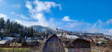 Dağlardaki eski ahşap ev. Köy karla kaplı..
