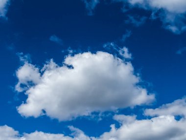 Mavi gökyüzü arka planında beyaz kabarık bulutlar.