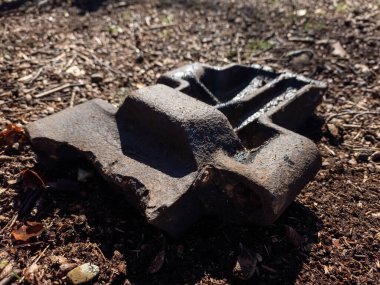 Siyah ve kırmızı paslı metal bir boru yığını.