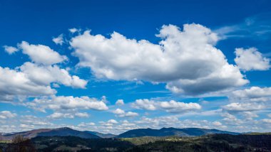 Bulutlu bir gökyüzünün altındaki dağ sırasının alçak açılı görüntüsü.