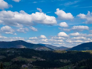 Karpat Dağları 'nın havadan görünüşü, Ukrayna. Mavi gökyüzü ve beyaz bulutlarla güzel bir sıradağ.