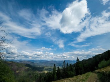 Dağları ve mavi gökyüzü olan güzel bir manzara.