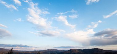 Bulutları ve gökyüzü olan güzel bir manzara.