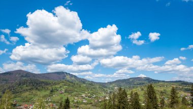Dağları ve mavi gökyüzü olan güzel bir manzara.