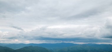 Bulutları ve mavi gökyüzü olan güzel bir manzara.