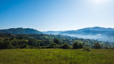 Dağlarda güzel yeşil ormanları ve bulutları olan dağ manzarası