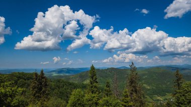 Yazın mavi gökyüzü ve bulutlarla dolu güzel dağ sıraları