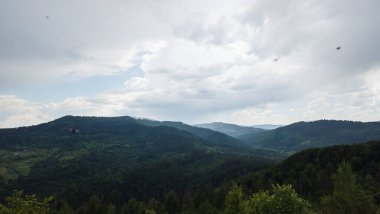 Yaz dağları manzarası, yeşil çimenler ve bulutlar.