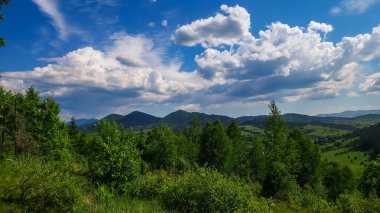 Dağları ve mavi gökyüzü olan güzel bir manzara.