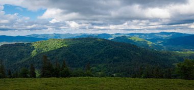 Yeşil ormanı ve bulutlu gökyüzü olan güzel dağ manzarası. Yazın Karpat Dağları