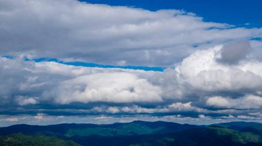 Dağları olan güzel bir manzara. Mavi gökyüzü ve beyaz bulutlar.