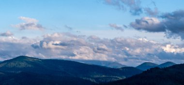 Dağları ve mavi gökyüzü olan güzel bir manzara.