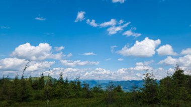 Dağları ve mavi gökyüzü olan güzel bir manzara.