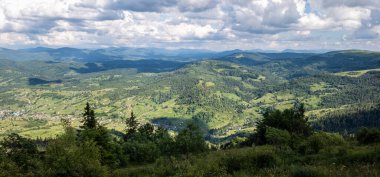 Yazın Karpatlar. Bulutlardaki dağlar, güneş ışınları yükseliyor..