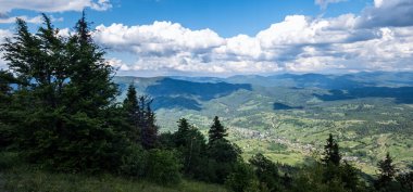 Dağları ve bulutlu gökyüzü olan güzel bir manzara..