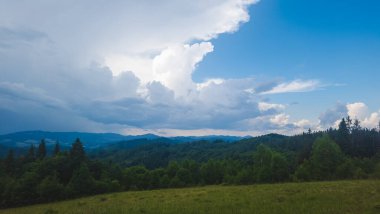 Dağları ve mavi gökyüzü olan güzel bir manzara.
