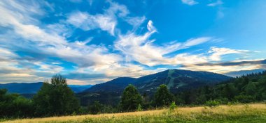Dağları ve mavi gökyüzü olan güzel bir manzara.
