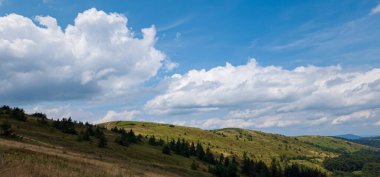 Dağları ve mavi gökyüzü olan güzel bir manzara.