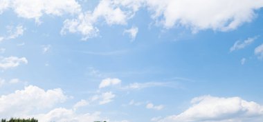 Mavi gökyüzüne karşı beyaz tüylü kümülüs bulutları