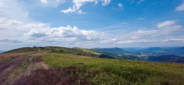 Dağları ve mavi gökyüzü olan güzel bir manzara.