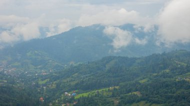 Bulutlu yeşil ve beyaz dağ manzarası, hava manzarası