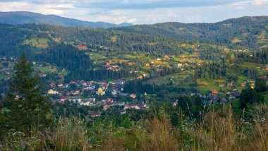 Renkli ağaçlarla, dağlarla ve köyle sonbahar manzarası