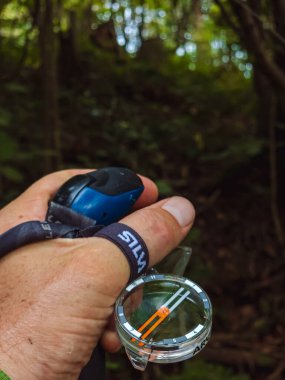 Orman yolunda pusula tutan adam.