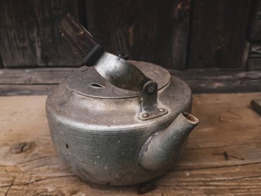 Ahşap arka planda eski paslı metal çaydanlık