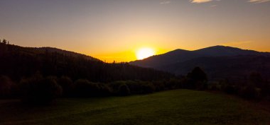 Arka planda dağ sırası olan güzel bir gün batımı..