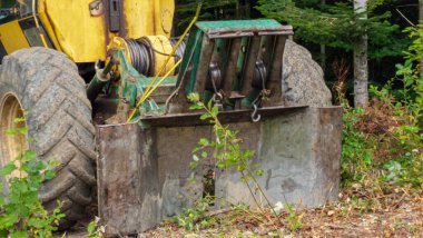 Büyük metal bir traktör kovayla kazıyor. Eski bir traktörün büyük kovası..