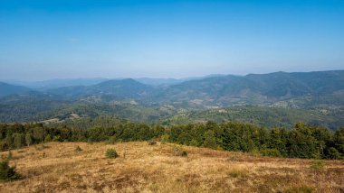 Dağları ve mavi gökyüzü olan güzel bir manzara.